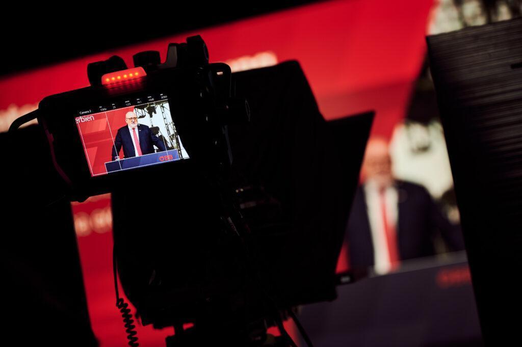 Nahaufnahme einer Studiokamera, die gerade eine Pressekonferenz aufnimmt.